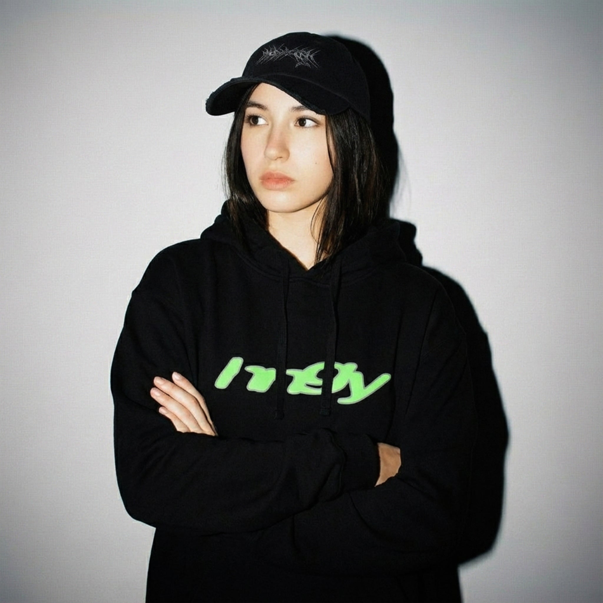 Full-body view of person wearing black HNGY hoodie with neon green logo