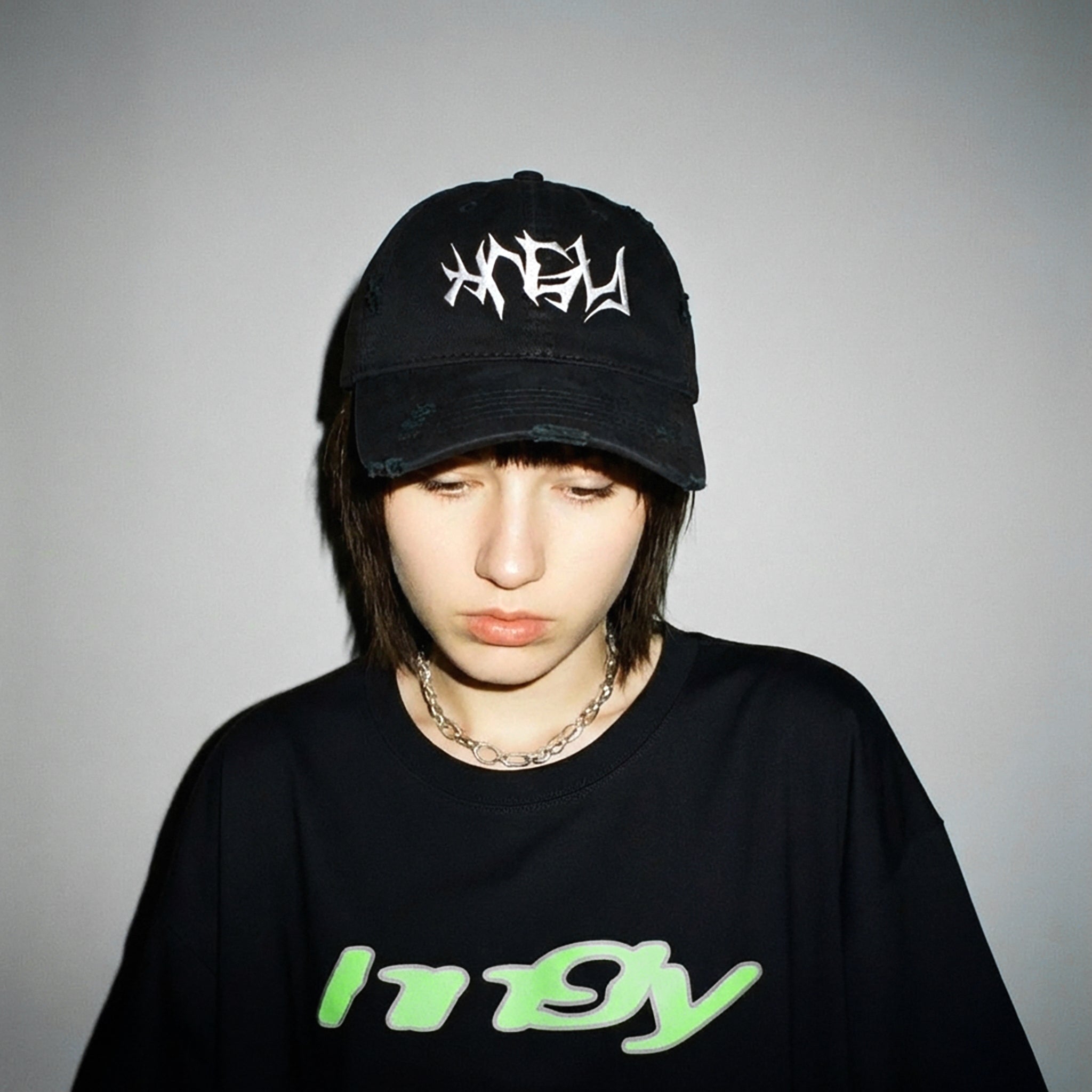 Model wearing the HNGY Distressed Bold Cap in black, front view.