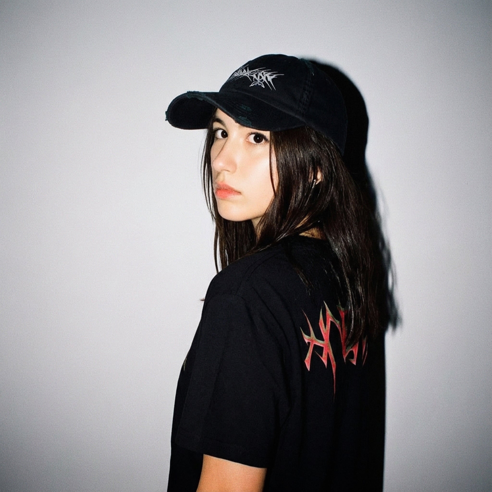 Model wearing the HNGY oversized t-shirt with flame design on the back, looking over the shoulder.